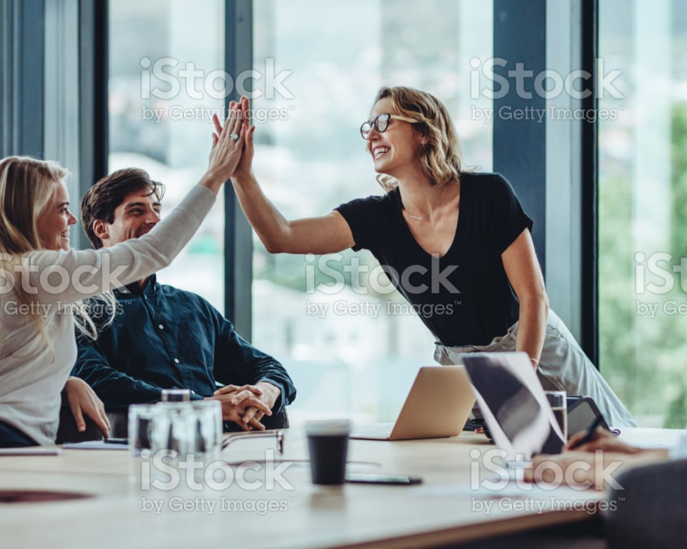 two people high-fiving across a conference table